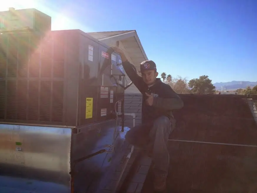 HVAC technician performing AC Tune-Up on a rooftop unit in Kihei